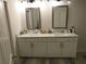 Bathroom featuring a double vanity with white cabinets, granite countertops and dual mirrors at 3411 Swallowtail Ter, Duluth, GA 30096