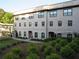 Exterior view of a multi-story townhome with brick facade and manicured landscaping at 3411 Swallowtail Ter, Duluth, GA 30096