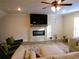 Bright living room featuring a fireplace with TV, fan and neutral decor at 3411 Swallowtail Ter, Duluth, GA 30096