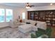 Inviting living room with large sectional sofa, custom built-in shelving, and a ceiling fan at 3411 Swallowtail Ter, Duluth, GA 30096