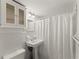 Bathroom features a pedestal sink, cabinet, and white tile at 3510 Roswell Nw Rd # N3, Atlanta, GA 30305