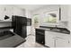 Modern kitchen features white cabinets, black appliances, and bright natural light at 3510 Roswell Nw Rd # N3, Atlanta, GA 30305