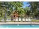 Community pool area with chairs, tables, and a playground in the background at 6090 River Chase Cir, Atlanta, GA 30328