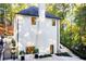 View of the rear exterior of the home, featuring a beautiful white brick facade, multiple windows, and manicured landscaping at 6090 River Chase Cir, Atlanta, GA 30328