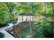 Stunning exterior view of a white two-story home nestled among lush greenery and a winding driveway at 6090 River Chase Cir, Atlanta, GA 30328