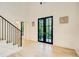 Bright foyer with light wood floors, striking black framed double doors, and modern staircase with black railing at 6090 River Chase Cir, Atlanta, GA 30328