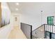 Bright hallway featuring hardwood floors, modern artwork, black metal railing, and a view from the upper level at 6090 River Chase Cir, Atlanta, GA 30328