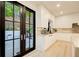 Modern kitchen with sleek white cabinets, marble countertops, and black framed doors leading to the backyard at 6090 River Chase Cir, Atlanta, GA 30328