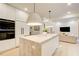 Bright kitchen with a large island, stainless steel appliances, modern lighting, and open layout to living area at 6090 River Chase Cir, Atlanta, GA 30328