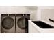 Modern laundry room with front-load washer and dryer units next to a sleek sink, providing functionality and style at 6090 River Chase Cir, Atlanta, GA 30328