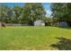 Expansive backyard featuring a lush lawn, mature trees, privacy fence, and garden shed at 3089 Ranlo Dr, Atlanta, GA 30340
