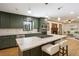 Open kitchen with an island, olive green cabinets, marble countertops and stainless steel appliances at 3089 Ranlo Dr, Atlanta, GA 30340