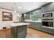 Modern kitchen featuring green cabinets, stainless steel appliances, a white countertop island, and natural light at 3089 Ranlo Dr, Atlanta, GA 30340