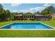 Stunning in-ground swimming pool set in a large yard with lush green grass and a back view of the home at 3089 Ranlo Dr, Atlanta, GA 30340