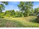 Large backyard featuring a green lawn and surrounding mature trees at 205 Cobb St, Palmetto, GA 30268
