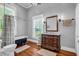 Elegant bathroom featuring a vintage clawfoot tub, a wooden vanity and stylish fixtures at 205 Cobb St, Palmetto, GA 30268