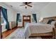 Spacious bedroom with a fireplace, wood floors, ceiling fan, and natural light at 205 Cobb St, Palmetto, GA 30268