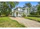 Classic two-story home with prominent columns, a cozy covered porch, and lush green lawns surrounding the property at 205 Cobb St, Palmetto, GA 30268