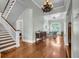 Inviting foyer with wood staircase, floors, chandelier and an entry to the sunroom, exudes classic elegance at 205 Cobb St, Palmetto, GA 30268