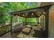 Covered back deck is great for outdoor gatherings, featuring stylish furniture and charming string lights at 4971 Fairhaven Ne Way, Roswell, GA 30075