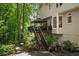 The backyard features a covered deck with lights, complemented by lush greenery and natural landscaping at 4971 Fairhaven Ne Way, Roswell, GA 30075