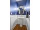 Powder room with stylish blue walls, white wainscoting, and a gold-framed mirror at 4971 Fairhaven Ne Way, Roswell, GA 30075