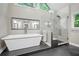 Bright bathroom features a soaking tub, glass enclosed shower, and a large mirror at 4971 Fairhaven Ne Way, Roswell, GA 30075