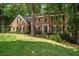 Traditional brick home with lush lawn, mature trees, black shutters, and a welcoming front entrance at 4971 Fairhaven Ne Way, Roswell, GA 30075