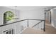 Upstairs hallway featuring railing, large arched window and views of the neighborhood at 4971 Fairhaven Ne Way, Roswell, GA 30075