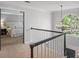 Upstairs hallway featuring railing, large arched window and view to the bedroom at 4971 Fairhaven Ne Way, Roswell, GA 30075