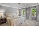 Bedroom with tray ceiling, neutral walls and carpet, plus ample natural light from two windows at 4971 Fairhaven Ne Way, Roswell, GA 30075