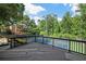Exterior view of a viewing deck overlooking well-maintained tennis courts surrounded by mature trees at 4971 Fairhaven Ne Way, Roswell, GA 30075