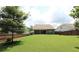 Spacious backyard featuring lush green grass, privacy fence, and a covered patio, ideal for outdoor gatherings at 5714 Pickens Garden Ln, Powder Springs, GA 30127