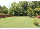 Expansive backyard surrounded by trees and a wooden fence at 5714 Pickens Garden Ln, Powder Springs, GA 30127