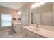 Beautiful bathroom with double vanity sinks, white cabinetry, large mirror, and a glass enclosed shower at 5714 Pickens Garden Ln, Powder Springs, GA 30127