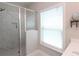 Modern bathroom features a glass door shower, a window for natural light, and a mirrored wall decor at 5714 Pickens Garden Ln, Powder Springs, GA 30127