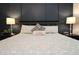 Comfortable bedroom with a queen size bed, stylish lamps, and decorative accents with dark accent wall at 5714 Pickens Garden Ln, Powder Springs, GA 30127