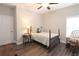 Cozy bedroom with a four-poster bed, wood floors, rocking chair, and a window for natural light at 5714 Pickens Garden Ln, Powder Springs, GA 30127