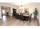 The dining room includes a large table with seating for 8, along with decorative light fixture and hardwood floors at 5714 Pickens Garden Ln, Powder Springs, GA 30127