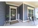 Cozy covered porch with seating, plants, and a welcoming entrance, ideal for relaxing outdoors at 5714 Pickens Garden Ln, Powder Springs, GA 30127
