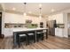 Modern kitchen with white cabinets, stainless steel appliances, and a spacious island with seating at 5714 Pickens Garden Ln, Powder Springs, GA 30127