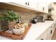 Beautiful kitchen with white cabinets, modern backsplash and quartz countertops and stainless steel appliances at 5714 Pickens Garden Ln, Powder Springs, GA 30127