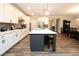 Bright kitchen features white cabinets, stainless steel appliances, and a large island with barstool seating at 5714 Pickens Garden Ln, Powder Springs, GA 30127