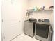 Well-equipped laundry room featuring modern washer and dryer, ample storage space, and stylish tile flooring at 5714 Pickens Garden Ln, Powder Springs, GA 30127