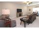 Cozy living room with a comfortable couch, a TV on a fireplace stand, and a ceiling fan at 5714 Pickens Garden Ln, Powder Springs, GA 30127