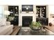 Cozy living room with fireplace, built-in bookshelves and a comfortable sofa with plant at 5714 Pickens Garden Ln, Powder Springs, GA 30127