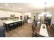 A large open space with kitchen with island seating, dining table, and comfortable living area with hardwood floors at 5714 Pickens Garden Ln, Powder Springs, GA 30127