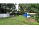Lush backyard with a shed, overgrown greenery and a barrel fire pit at 8436 Magnolia Dr, Jonesboro, GA 30238