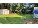 Spacious backyard featuring green grass, sheds, and mature trees at 8436 Magnolia Dr, Jonesboro, GA 30238