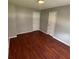 Neutral bedroom with hardwood flooring and two closet doors at 8436 Magnolia Dr, Jonesboro, GA 30238